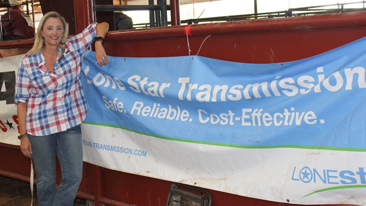 woman in front of rodeo sponsorship banner